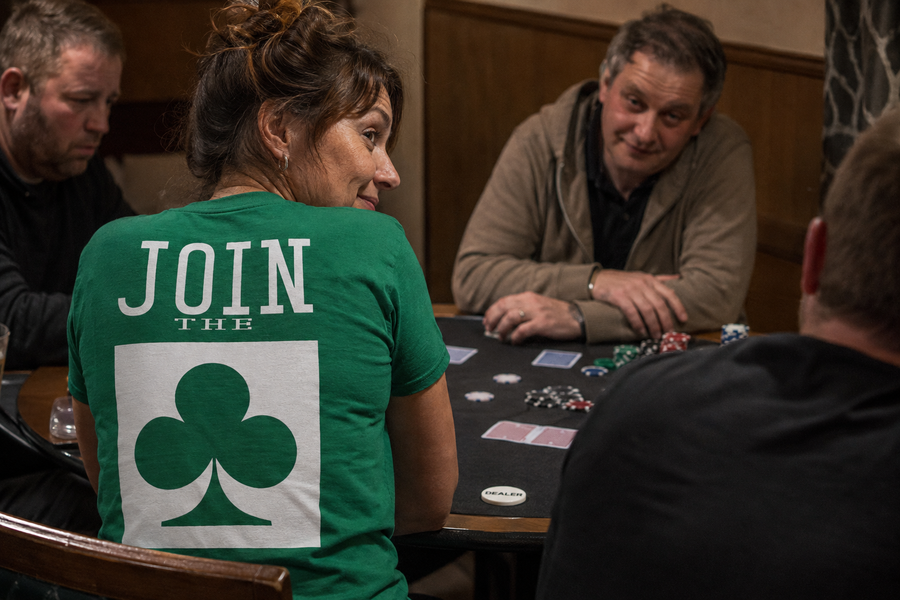 Woman wearing the green JOIN THE CLUB T-shirt during a poker game