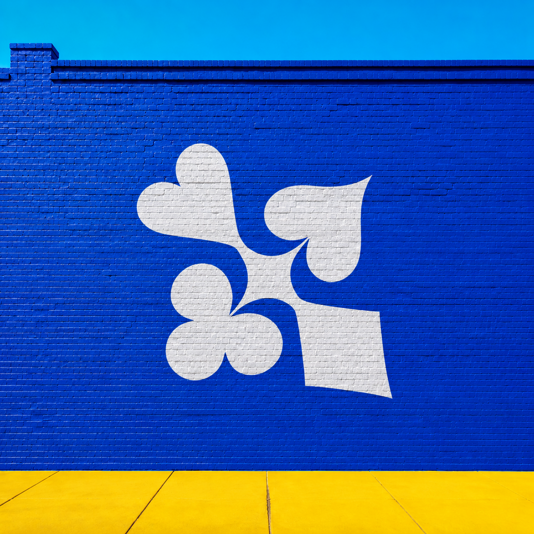 White Hot four-suits logo mural on a bright blue wall for poker streetwear