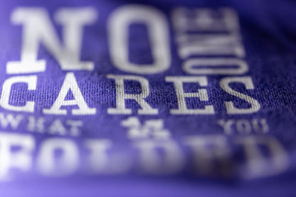 Close-up print detail of NO ONE CARES WHAT YOU FOLDED on purple poker T-shirt