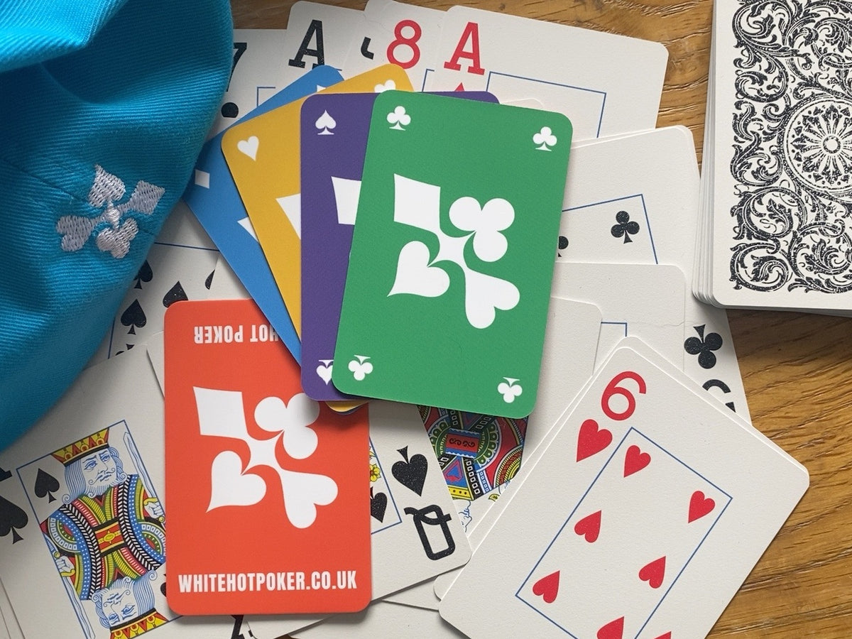 WHITE HOT POKER branded playing cards with blue embroidered poker cap and scattered playing cards